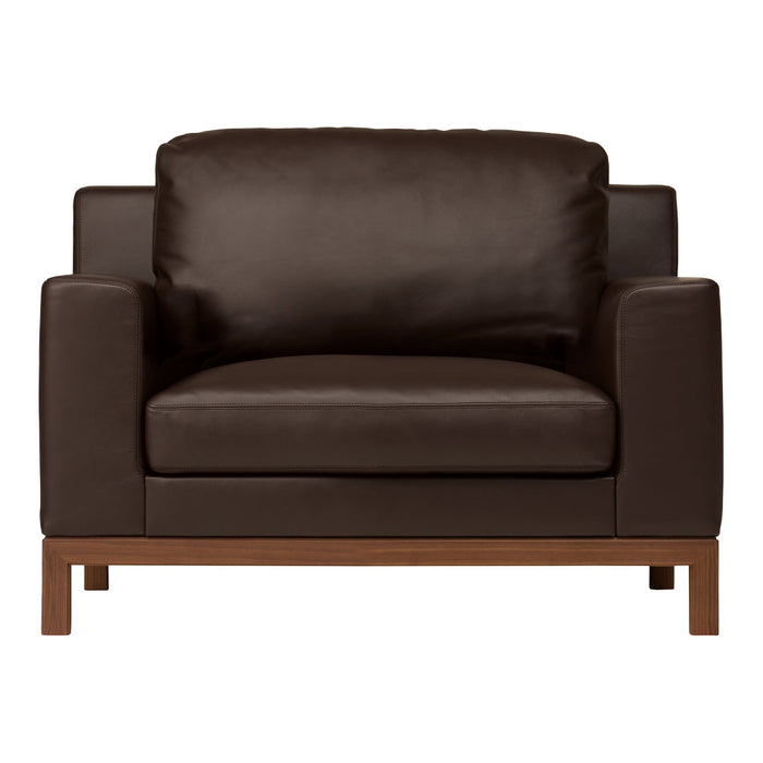 Brown leather armchair with a smooth surface and a minimalist wooden base, perfect for modern decor.