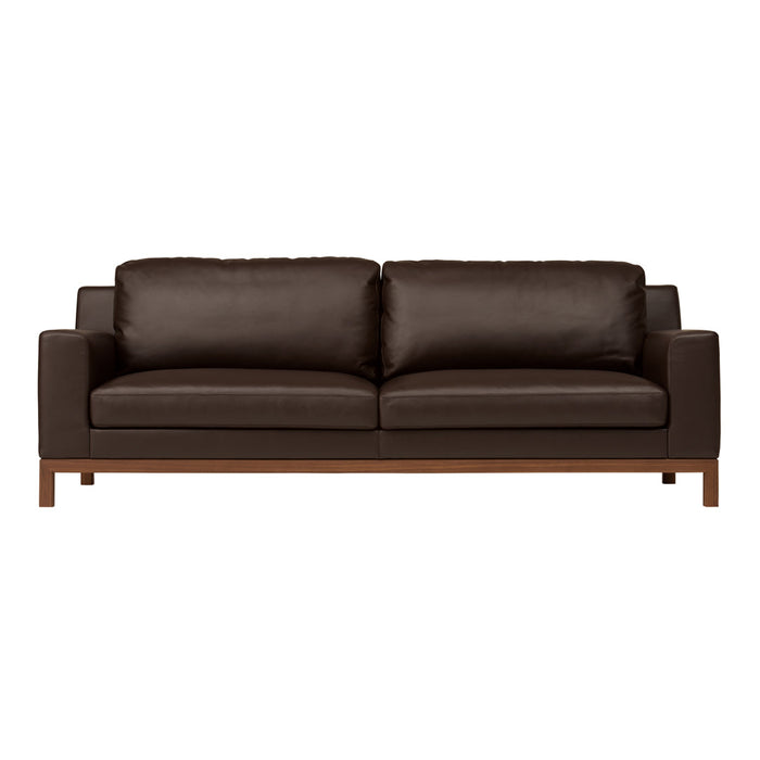 Brown leather sofa with sleek lines and wooden legs, featuring a smooth, minimalist design for modern interiors.