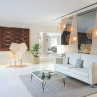 Bright white walls, natural wood accents, earthy tones, and woven textures create a modern, inviting living space.