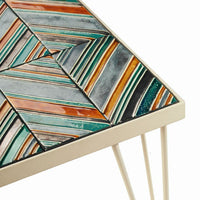 Colorful geometric tile patterns in teal, orange, silver, and black on a modern table surface.