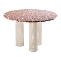 Round table with a speckled orange and white marble top and beige mesh base, showcasing modern design and texture.