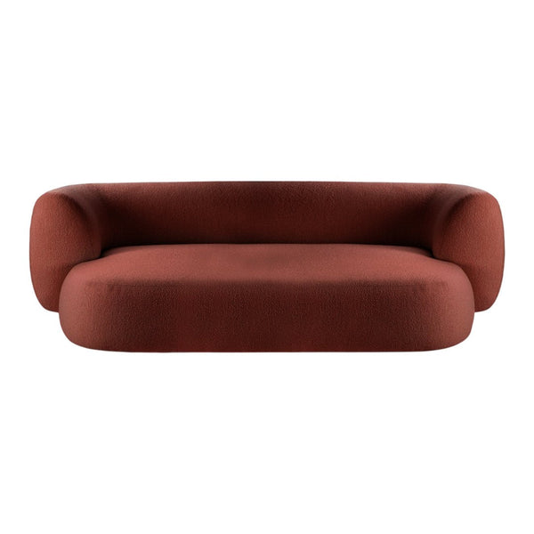 Terra-cotta colored modern sofa with a smooth, rounded design and textured fabric. Ideal for contemporary interiors.