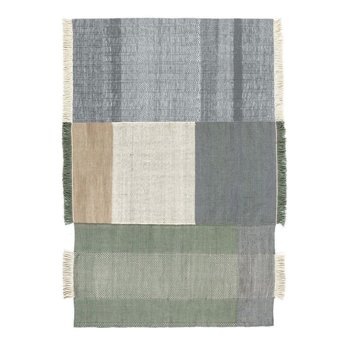 Multicolored area rug featuring gray, green, beige, and cream blocks with textured stripes and fringed edges.