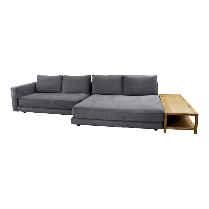 Gray sectional sofa with clean lines and smooth texture, complemented by a natural wood side table. Modern and minimalist design.