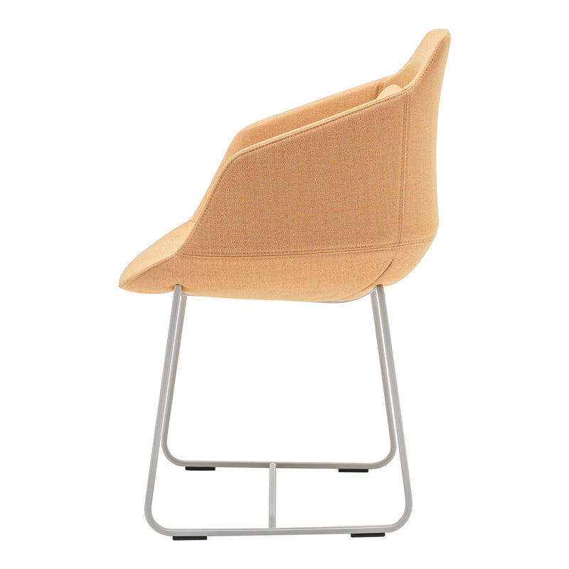 Side view of a modern chair featuring soft peach fabric and minimalist silver metal legs.