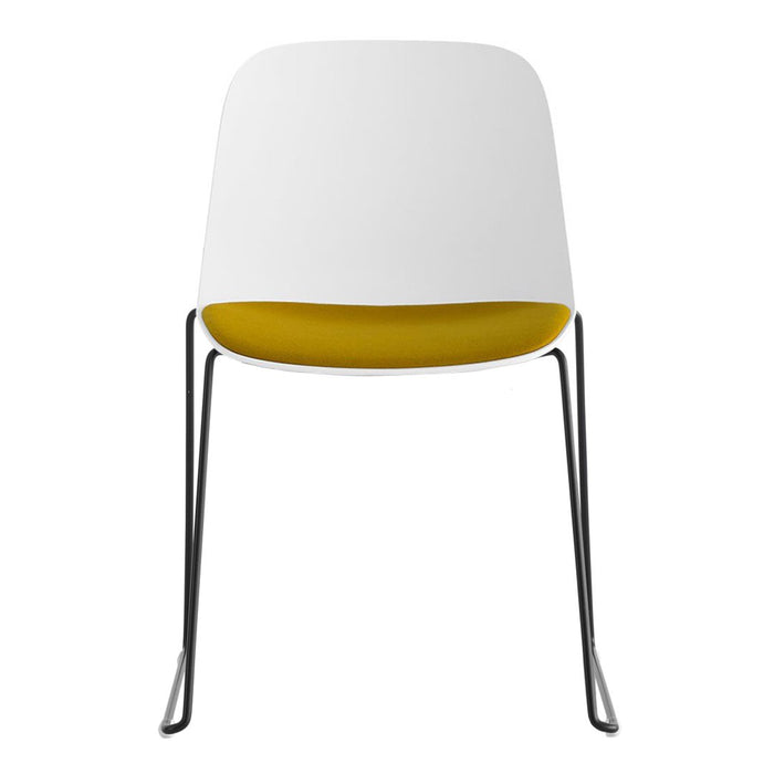 Modern chair with a sleek white exterior and vibrant yellow interior, featuring minimalist design and chrome legs.