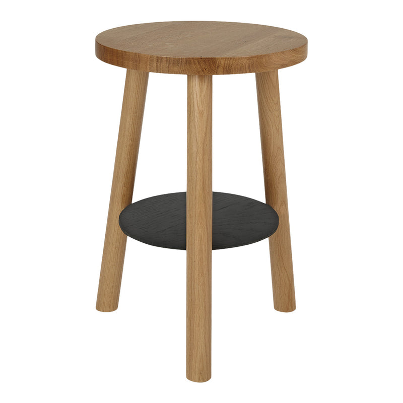 Natural wood round side table with light oak finish and a contrasting black shelf beneath.