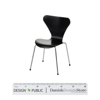 Black chair with a sleek, modern design and smooth surface, supported by slender metal legs.