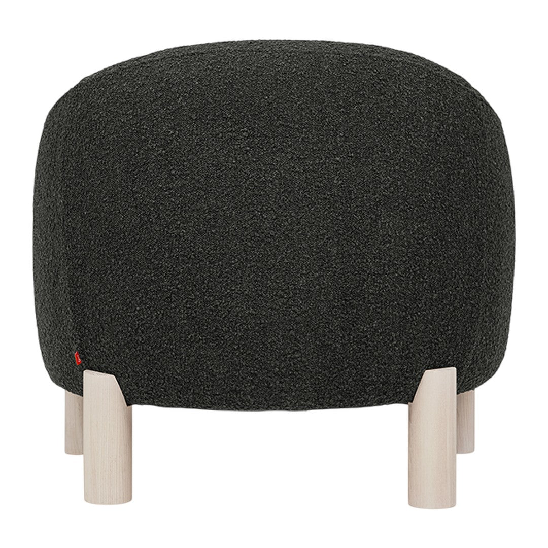 Round ottoman in textured dark green fabric with natural wood legs, featuring a minimalist design.