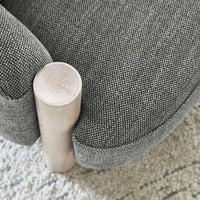 Gray textured fabric with subtle pattern on a rounded chair, featuring a light wood leg for contrast.