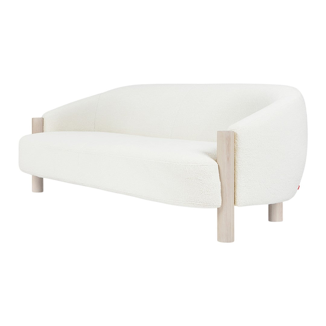 Modern white sofa with a minimalist design and light wood legs, featuring a smooth, upholstered texture.