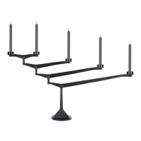 Sleek black candle holder with five arms, featuring a minimalist design and contrasting gold candle tips.