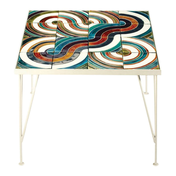 Colorful patterned table featuring swirling blue, red, and white designs on a glossy surface. White metal legs.