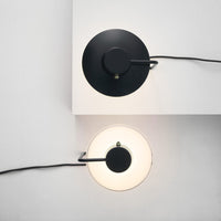 Two modern wall lamps featuring a black round base and a white circular shade for a stylish contrast.