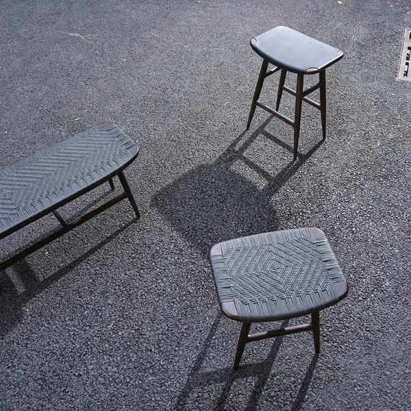 Set of three grey stools with textured patterns, featuring a sleek, modern design on a dark surface.