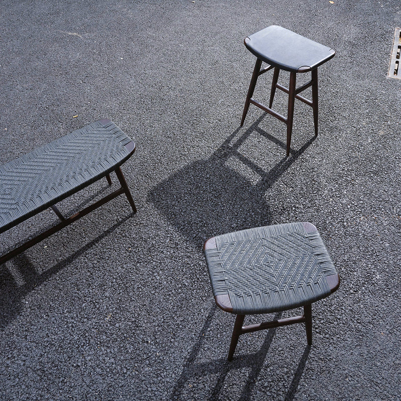 Set of three grey stools with textured patterns, featuring a sleek, modern design on a dark surface.