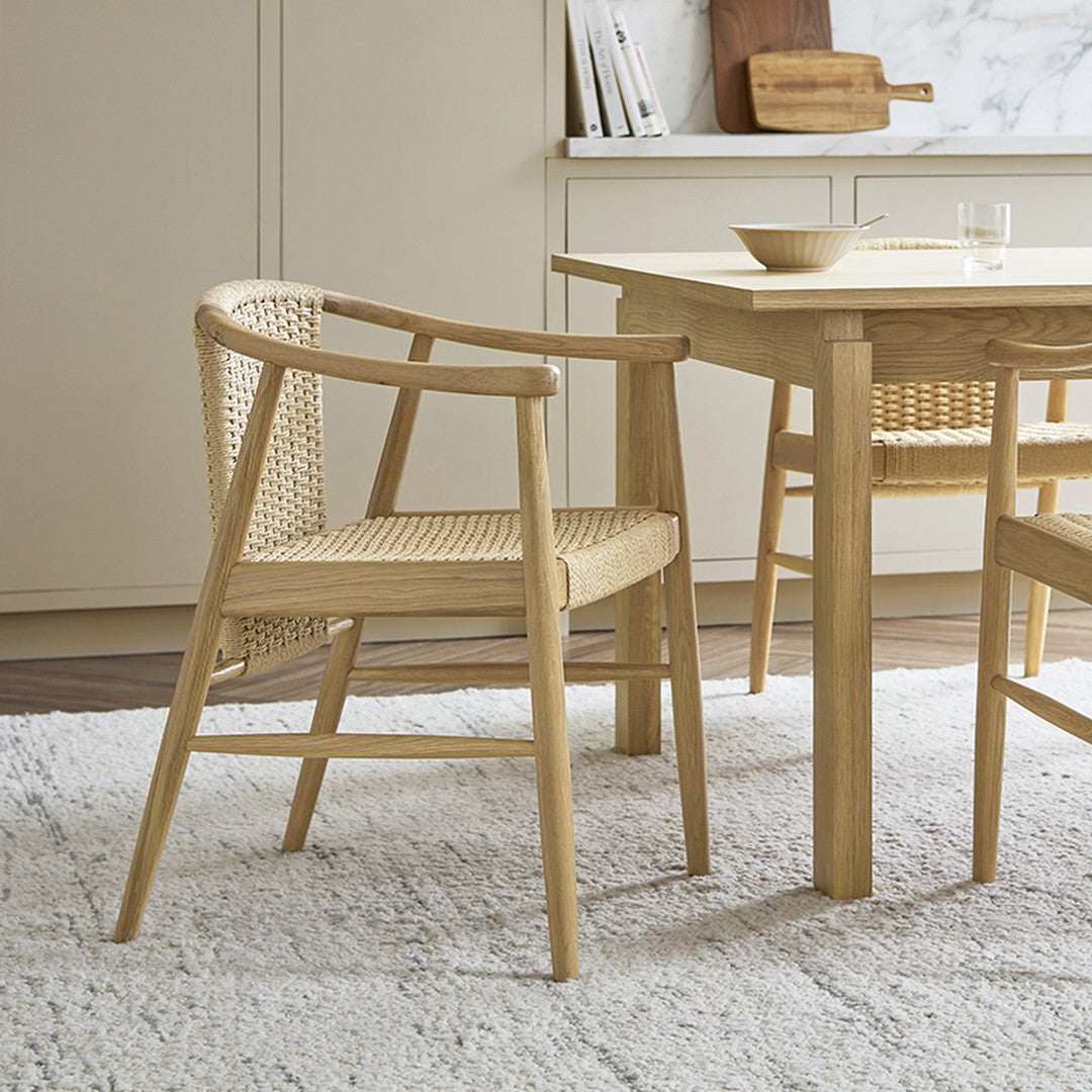 Light oak dining chair with woven rattan accents, showcasing natural tones and a minimalist design.
