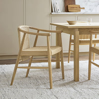 Light oak dining chair with woven rattan accents, showcasing natural tones and a minimalist design.
