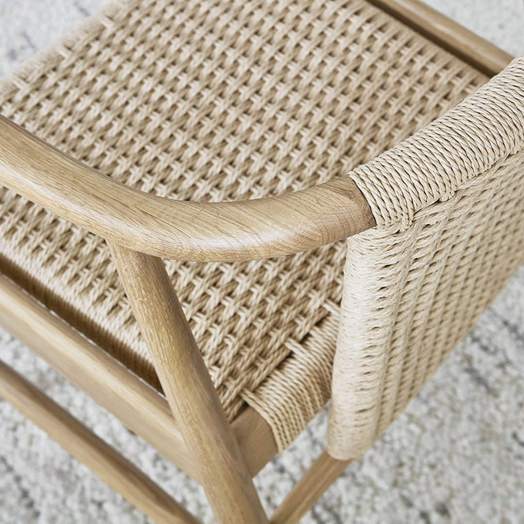 Natural woven beige chair with textured patterns, showcasing a sleek wooden frame and intricate seat design.