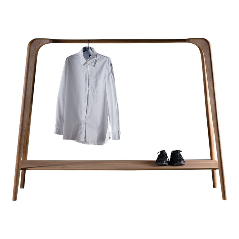Minimalist wooden clothing rack with a white shirt hanging and black shoes on the shelf, showcasing clean lines and natural hues.