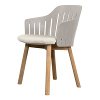 Light gray armchair with a slatted back and cream-colored cushion, featuring natural wooden legs. Modern, stylish design.