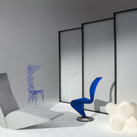 Gray lounge chair, vibrant blue accent chair, and translucent white light fixture against a minimalist backdrop.