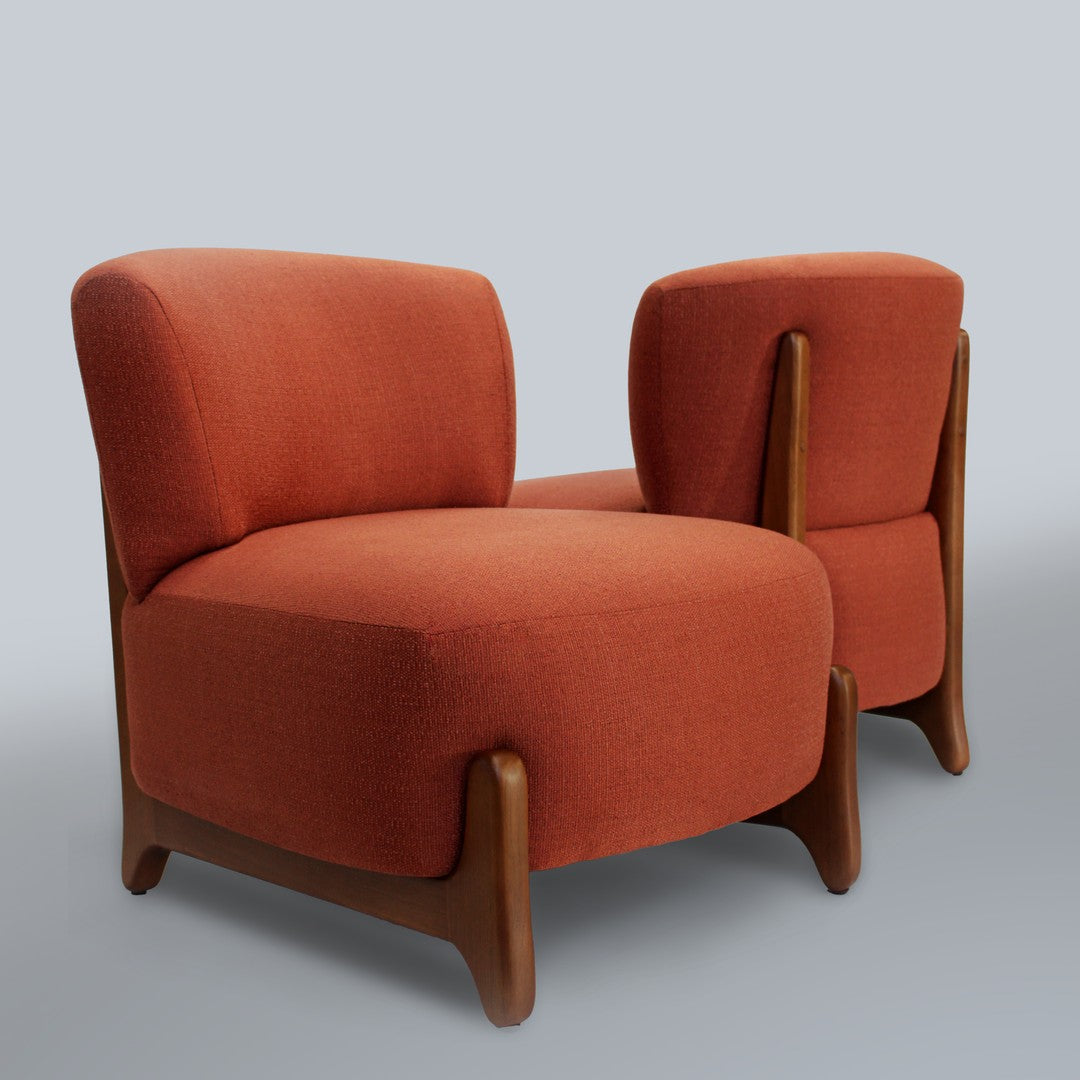 Two mid-century modern chairs in vibrant rust orange fabric with wooden legs, showcasing a sleek, minimalist design.