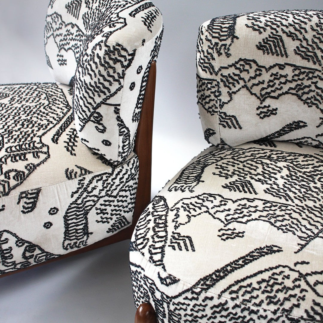 "Black and white upholstered chairs featuring intricate animal and abstract patterns."