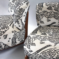 "Black and white upholstered chairs featuring intricate animal and abstract patterns."