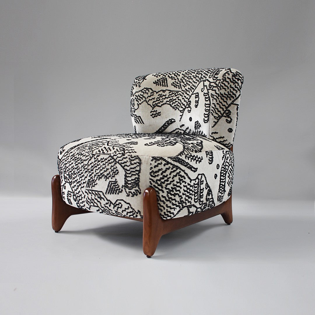 Black and white abstract pattern on upholstered chair with sleek wooden legs. Unique, modern design for stylish decor.