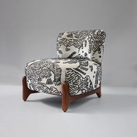 Black and white abstract pattern on upholstered chair with sleek wooden legs. Unique, modern design for stylish decor.