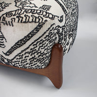 Black and white patterned upholstery with a wooden leg, adding a stylish touch to your home decor.