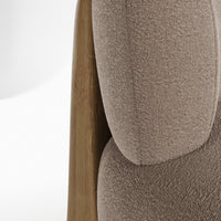 Textured taupe upholstery on a curved chair with natural wood accents, showcasing a modern, minimalist design.