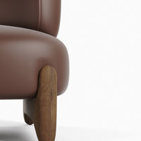 Brown leather armchair with a smooth finish and wooden legs, showcasing a modern, minimalist design.