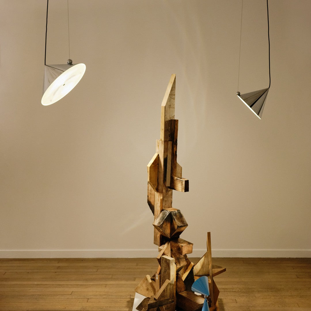 Abstract wood sculpture featuring a mix of natural tones and geometric patterns, complemented by minimalistic lighting.