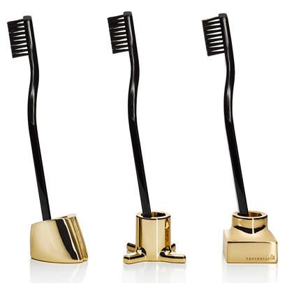 Set of three sleek black toothbrushes with elegant gold bases, showcasing modern design and luxurious colors.