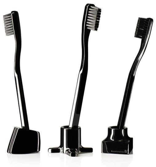 Set of three black toothbrushes with sleek designs and varying ergonomic shapes. Elegant and modern aesthetic.