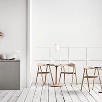 Modern wood dining set with light oak chairs and tabletop, complemented by a minimalistic white and gray color scheme.