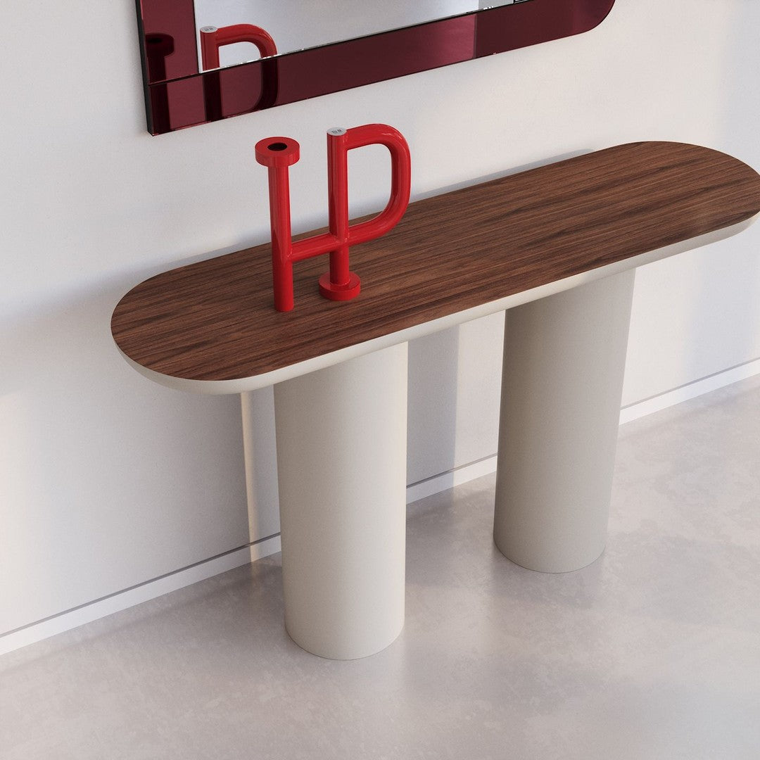 Modern console table with a brown wood top and cream cylindrical legs, accented by a bright red decorative piece.