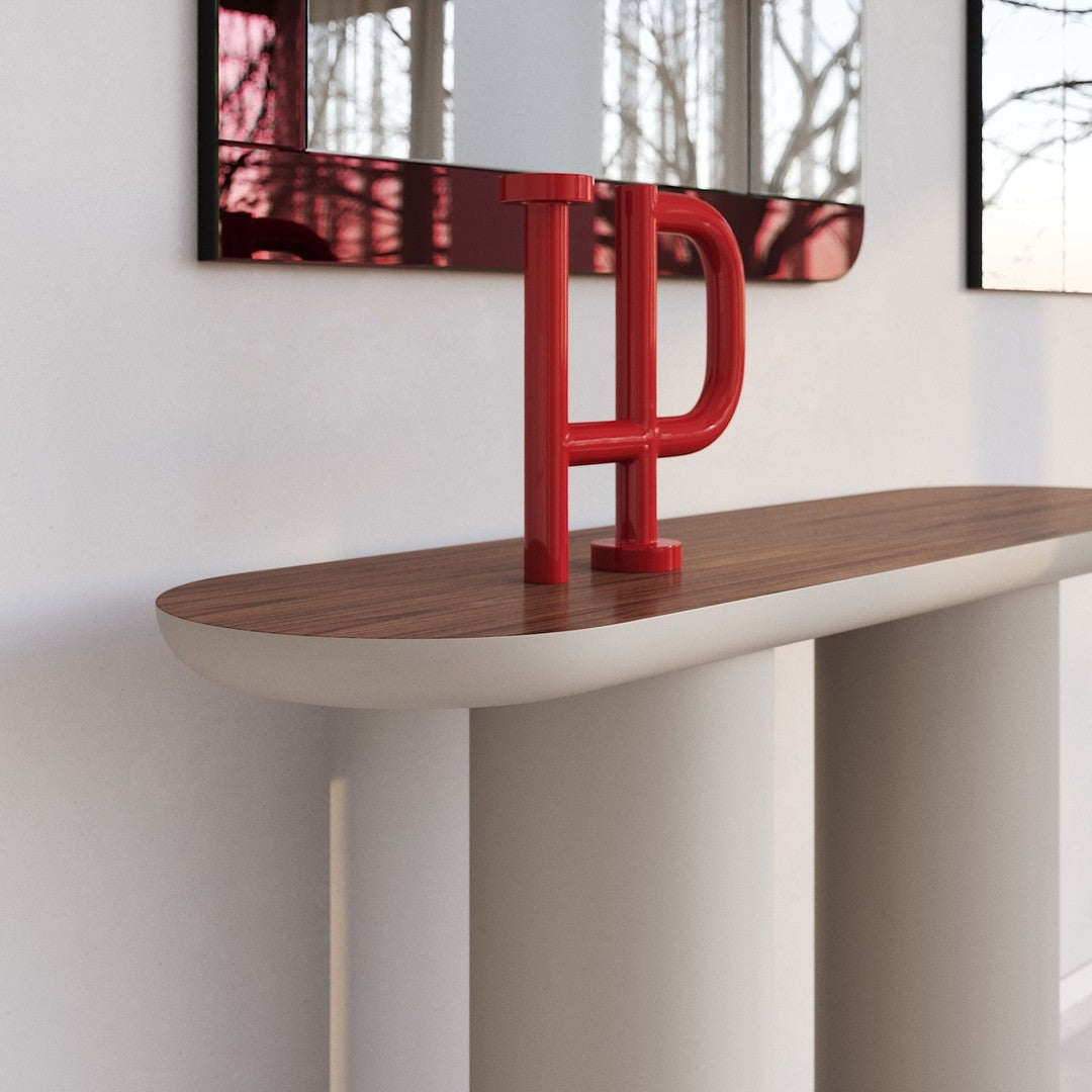 Red and wooden console table with smooth curved base and a sleek surface, showcasing modern design elements.