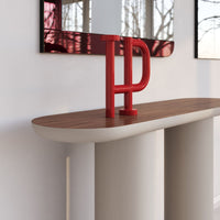 Red and wooden console table with smooth curved base and a sleek surface, showcasing modern design elements.