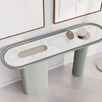 Elegant oval console table with a marble pattern top and soft green cylindrical legs, featuring minimalist design elements.