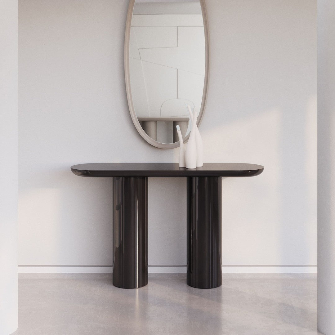 "Elegant black console table with smooth finish and modern cylindrical legs, set against a light, minimalist backdrop."