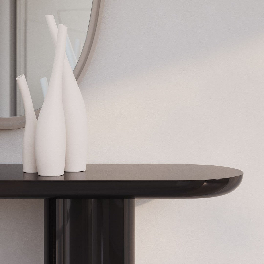 White minimalist vases on a sleek black tabletop, featuring smooth lines and modern design.