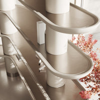 Sleek beige and cream curved shelves with minimalist design, accented by touches of warm autumn foliage.