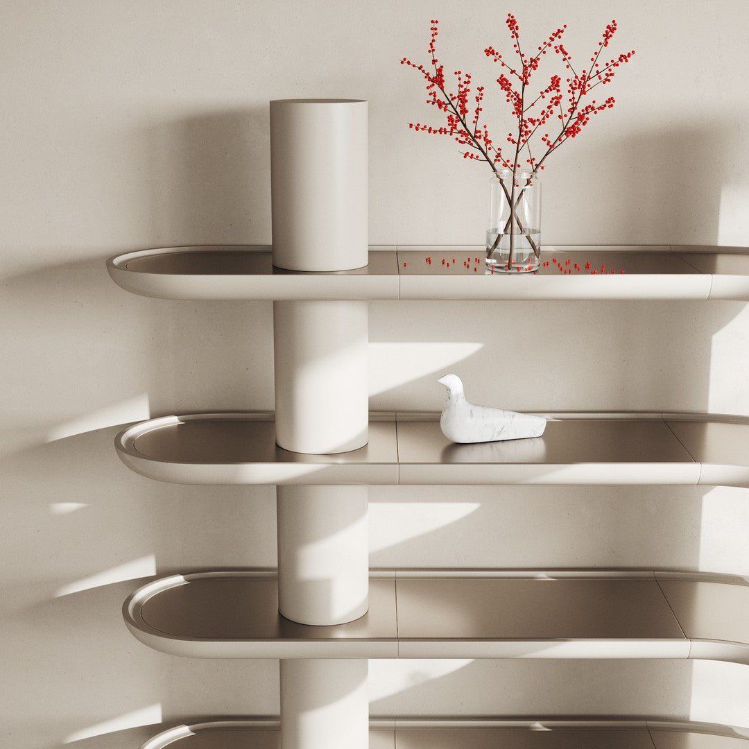 Minimalist shelving unit in soft beige with smooth, rounded edges and a subtle glossy finish, accented by red floral decor.