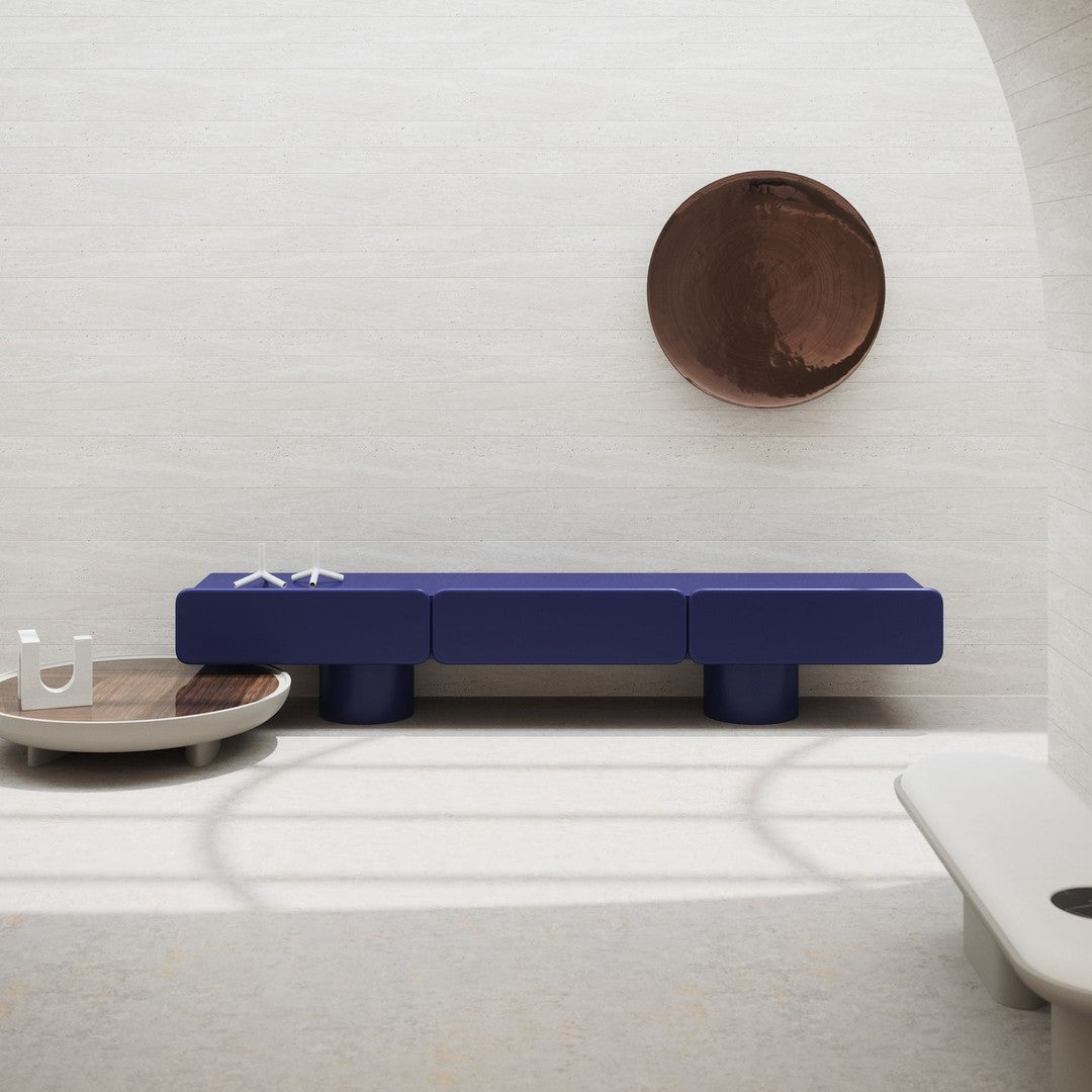 Navy blue modern coffee table with clean lines, paired with earthy tones and smooth surfaces in a minimalist setting.