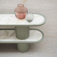Green and white marble tabletop with soft curves, featuring a textured grey base and decorative glass vases.