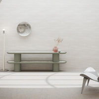 Modern green console table with smooth, rounded edges and a sleek, minimalistic design against a textured neutral backdrop.