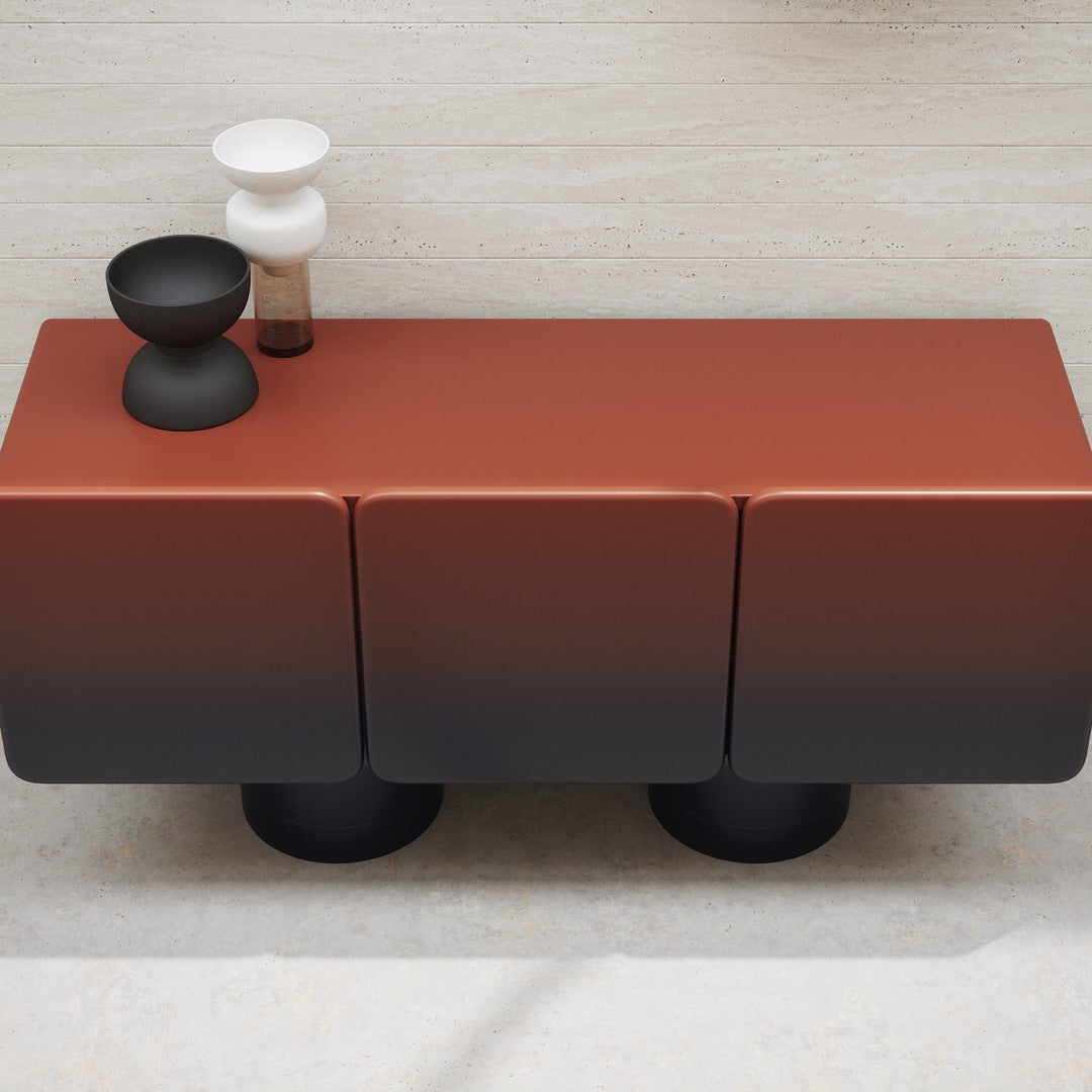 Modern three-drawer sideboard in gradient terracotta and black, topped with minimalist black and white decor.